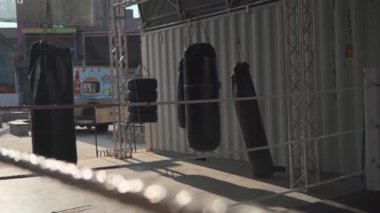 Sokak spor salonundaki boks ve dövüş sanatları alanında bir sürü kum torbası var. Spor, dövüş ve kum torbalarıyla tekmeleme sporları için şehir dışında bir alan. Boks eğitimi için kendi ellerimle yaptım.. 