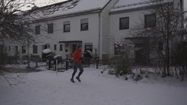 Людина Біжить Сніговою Стежкою Через Парк Місті Слухаючи Музику Навушниках — стокове відео
