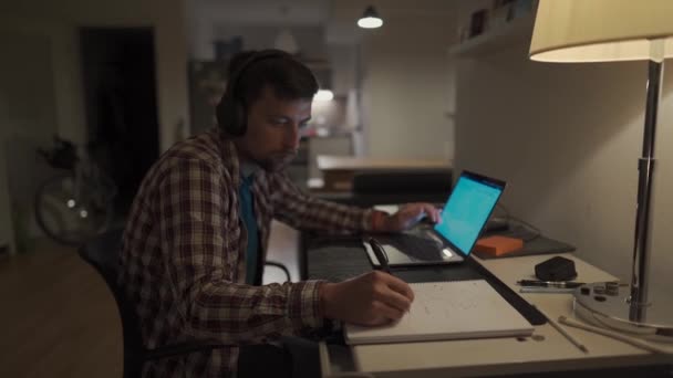 Student Dělá Domácí Úkoly Notebooku Poslouchá Hudbu Sluchátkách Muž Studuje — Stock video
