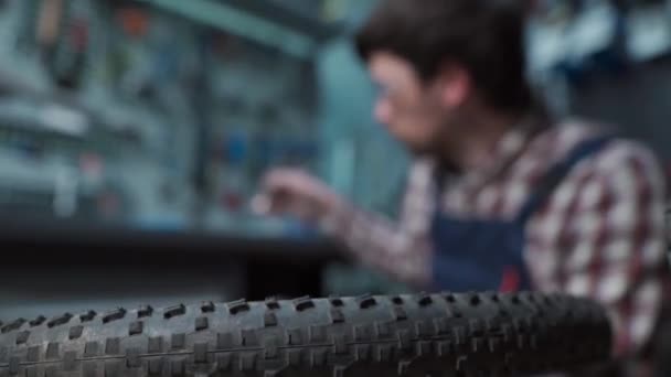 修理车间的男自行车技工 修理自行车轮 更换后轮毂轴承 循环轮毂球轴承的重新组合及润滑 自行车修理工在工作 车间技术员 — 图库视频影像