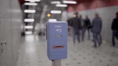 Münih, Almanya 'da metroda arka planda yürüyen yolcular için mavi renkli toplu taşıma bileti onaylayıcısı. Munchen, Deuschland 'daki metro istasyonunda toplu taşıma bilet damgası makinesi.. 