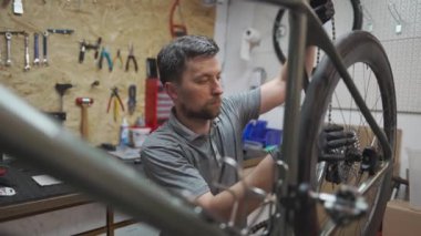 Bisiklet tamircisi bisikletle bisiklet zinciri kurar. Teknisyen bisiklet tamirhanesinde bisiklet zinciri tamir ediyor. Bisiklet tamircisi bisiklet zincirini ayarlar. Makine mühendisi atölyede şanzımanı tamir ediyor.