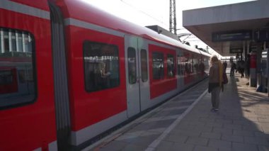 15 Nisan 2022. Münih, Almanya. Münih, Bayern 'deki S-Bahn istasyonu Hackerbrucke. Deutschland' deki demiryolu taşımacılığı teması. Banliyö hızlı treni Deutsche Bahn istasyonda kırmızı renkli. 