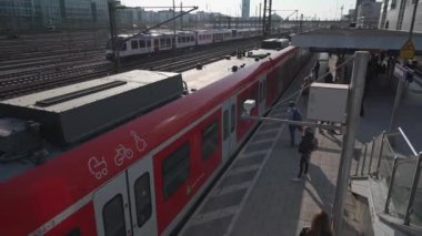 15 Nisan 2022. Münih, Almanya. Münih, Bayern 'deki S-Bahn istasyonu Hackerbrucke. Deutschland' deki demiryolu taşımacılığı teması. Banliyö hızlı treni Deutsche Bahn istasyonda kırmızı renkli. 