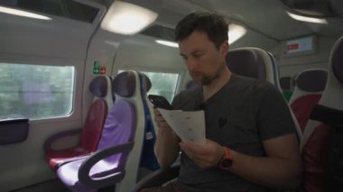 Roma, İtalya 'da güneşli bir yaz gününde elinde biletlerle renkli koltukları olan boş bir İtalyan treninde seyahat eden genç bir adam. Tren yolu üzerindeki turist gezileri telefonla kontrol ediliyor.