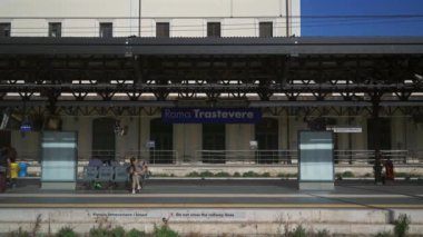 9 Ekim 2023. Roma. İtalya. Roma Trastevere tren istasyonu. Yolcular güneşli yaz havasında İtalya 'daki Trastevere tren istasyonunda tren bekliyor. İtalya 'daki kamu demiryolu sistemi. Trenital