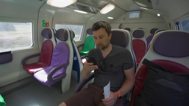 Νεαρός Που Ταξιδεύει Ένα Άδειο Ιταλικό Τρένο Πολύχρωμα Καθίσματα Χρησιμοποιώντας — Αρχείο Βίντεο