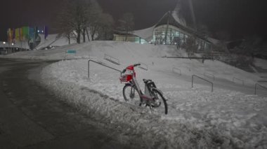 Münih Olimpiyat Parkı, Almanya 'da kışın geceleri kar yağar. Kar kış akşamı geç saatlerde Olimpiyat parkını insanlar olmadan kapladı. Olympiapark Münih. Olympia Parkı Muenchen. 