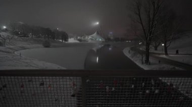 Münih Olimpiyat Parkı, Almanya 'da kışın geceleri kar yağar. Kar kış akşamı geç saatlerde Olimpiyat parkını insanlar olmadan kapladı. Olympiapark Münih. Olympia Parkı Muenchen. 