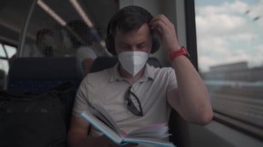 Yazın kablosuz kulaklıklar ve kitap okuma ile Deutsche treniyle seyahat eden yolcular. Öğrenci trende giderken kablosuz kulaklıkla ders kitabı okuyor. Üniversiteye günlük gidiş-dönüş. 