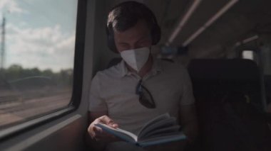 Yazın kablosuz kulaklıklar ve kitap okuma ile Deutsche treniyle seyahat eden yolcular. Öğrenci trende giderken kablosuz kulaklıkla ders kitabı okuyor. Üniversiteye günlük gidiş-dönüş. 