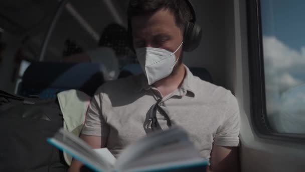 Blanke Man Met Een Masker Een Koptelefoon Trein Zittend Aan — Stockvideo