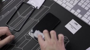 Erkek eli hazırlama ve akıllı telefona ekran koruyucusu yerleştirme. Akıllı telefon ekranına koruyucu sayfa ekleme görüntüsü. Isınmış cam koruyucu. Bakım ve onarım