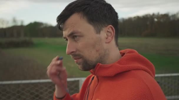 Müzikle Koşmak Adam Sonbaharda Dışarıda Koşuya Başlamadan Önce Kulaklıklarına Dinleme — Stok video