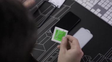 20 Kasım 2023. Münih. Almanya. Adam, Iphone 15 PRO için kentsel zırh teçhizatı GLASS PROTECTOR SHIELD PLUS 'u kuruyor. UAG Glass Shield Plus Premium ekran koruyucuları. Koruyucu cam takılıyor. 