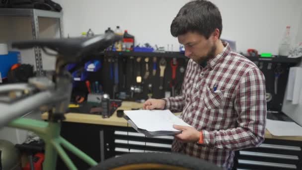 Bisiklet Teknisyeni Idari Işler Yapıyor Motosiklet Tamircisi Belgelerini Notlar Bisiklet — Stok video