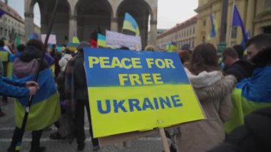 Almanya 'nın Münih kentindeki Odeonsplatz' da Ukrayna 'da savaşa karşı düzenlenen gösteriler sırasında Ukrayna' nın özgür kalması için mavi sarı poster üzerine yazı. Ukrayna 'daki savaşı protesto eden pankartlar ve pankartlar.. 