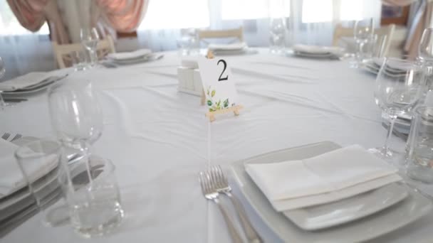 テーブルウェア付きのレストランのテーブル番号は 人や食べ物なしのお祝いのイベントに用意されています 装飾された結婚式のテーブル ゲストテーブル番号 レストランのウェディングテーブル ウェディング バンケット — ストック動画