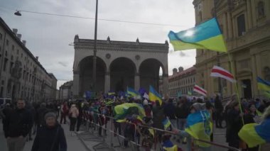 18 Şubat 2023. Münih, Odeonsplatz Almanya. Münih 'teki Odeonsplatz' da Rusya ile Ukrayna arasındaki işgal ve savaşa karşı Ukraynalı mültecilerin gösterisi. Almanya 'da savaş karşıtı protesto. 