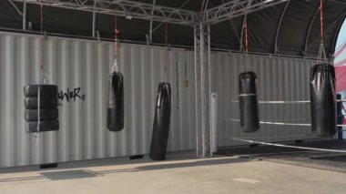 Sokak spor salonundaki boks ve dövüş sanatları alanında bir sürü kum torbası var. Spor, dövüş ve kum torbalarıyla tekmeleme sporları için şehir dışında bir alan. Boks eğitimi için kendi ellerimle yaptım.. 