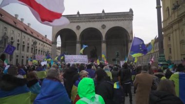 18 Şubat 2023. Münih, Odeonsplatz Almanya. Münih 'teki Odeonsplatz' da Rusya ile Ukrayna arasındaki işgal ve savaşa karşı Ukraynalı mültecilerin gösterisi. Almanya 'da savaş karşıtı protesto. 