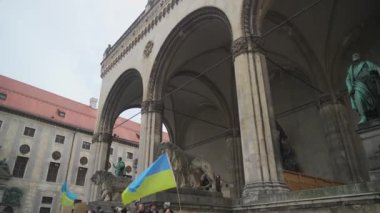 18 Şubat 2023. Münih, Odeonsplatz Almanya. Münih 'teki Odeonsplatz' da Rusya ile Ukrayna arasındaki işgal ve savaşa karşı Ukraynalı mültecilerin gösterisi. Almanya 'da savaş karşıtı protesto. 