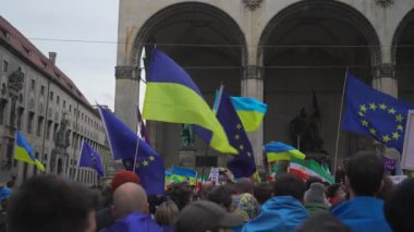 18 Şubat 2023. Münih, Odeonsplatz Almanya. Münih 'teki Odeonsplatz' da Rusya ile Ukrayna arasındaki işgal ve savaşa karşı Ukraynalı mültecilerin gösterisi. Almanya 'da savaş karşıtı protesto. 