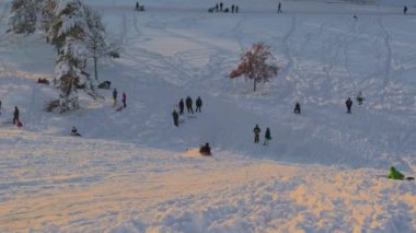Münih, Almanya, Riemer Park, Messestadt. Riem parkındaki Toboggan tepesi ve gözlem güvertesi tepesi. Güneşli kış havasında Münih 'te bir parkta karlı dağda kayak yapan mutlu insanlar.. 