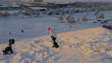 3 Aralık 2023. Münih, Almanya, Riemer Park, Messestadt. Riem parkındaki Toboggan tepesi ve gözlem güvertesi tepesi. Güneşli kış havasında Münih 'te bir parkta karlı dağda kayak yapan mutlu insanlar.. 