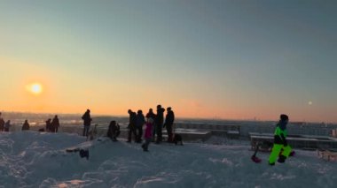 3 Aralık 2023. Münih, Almanya, Riemer Park, Messestadt. Riem parkındaki Toboggan tepesi ve gözlem güvertesi tepesi. Güneşli kış havasında Münih 'te bir parkta karlı dağda kayak yapan mutlu insanlar.. 