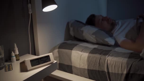 Стрессовый Человек Пытается Уснуть Сосредоточьтесь Электронных Часах Бессонный Человек Страдает — стоковое видео