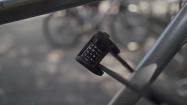 Hırsızlığa ve hırsızlığa karşı bisiklet sağlama almak. Bir motorun üzerindeki katlanmış metal kombinasyon kilidinin yakın çekimi. Dört haneli şifresi olan bir asma kilit. Bisikletler için araç hırsızlığı önleyici cihaz. 