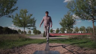 Spor ayakkabılı adam Almanya 'da bir parkta lastikten ip dengeleyerek yürümeyi ve dengeyi öğreniyor. Spor, eğlence, eğlence ve sağlıklı aktif yaşam tarzı konsepti. Acemi açık havada dengede durur.. 
