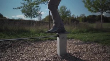 Ayakkabılı acemi, Almanya 'da parkta lastik halatla yürümeyi ve dengeyi sağlamayı öğreniyor. Adam Münih 'teki spor salonunda gergin bir iple dengede duruyor. Halatla kayma. Halat bandı. Plastik halatı dengeliyorum.. 