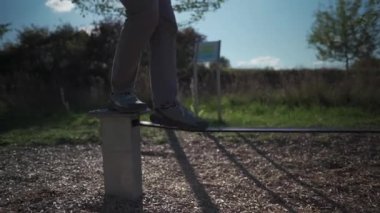 Spor ayakkabılı adam Almanya 'da bir parkta lastikten ip dengeleyerek yürümeyi ve dengeyi öğreniyor. Spor, eğlence, eğlence ve sağlıklı aktif yaşam tarzı konsepti. Acemi açık havada dengede durur.. 