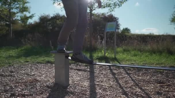 德国一名穿着鞋子的初学者在公园里学习走路 并在橡胶松驰线上保持平衡 在慕尼黑的城市体育馆里 男人们靠拉长的绳子保持平衡 松紧带 平衡橡胶绳 — 图库视频影像