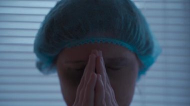 Travma geçirmiş, yüzü yaralanmış hastane elbisesi içinde dua eden ve ağlayan bir kadın. Klinikteki hasta dua ediyor ve Tanrı 'dan yardım istiyor. Kazadan sonra korkan ve ambulansta dua eden biri. İnanç ve din. 