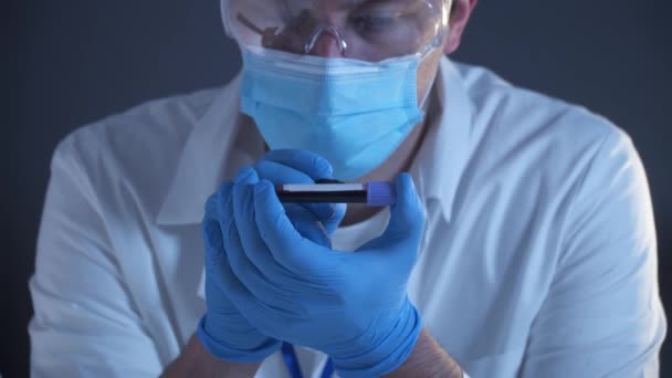 医師は 血液マークとラベル付きコロナウイルスCovid 19と実験室試験管を保持しています 2019 Ncvコロナウイルス 手袋を手に医師の積極的な血液サンプル 研究室での分析 — ストック動画