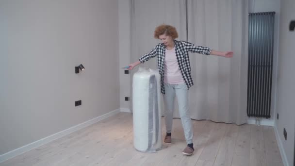 Hausfrau Öffnet Eine Neu Gekaufte Latexmatratze Aus Einer Vakuumrolle Ohne — Stockvideo