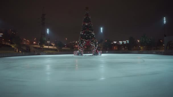キエフ 夜にウクライナで新年の木で飾られた空のスケートリンクのビュー アイススケートのテーマ 冬時間 ロックダウン中の屋外活動 コロナウイルスパンデミックの隔離Covid — ストック動画