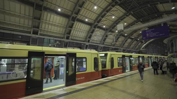 2023年12月25日德国柏林 Bahnhof Alexanderplatz在晚上 德国柏林市中心的城市火车站 Bahn Alexanderplatz乘客乘坐黄色通勤列车到达并离开 — 图库视频影像