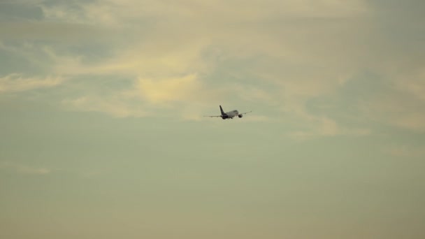 日没時にドイツのミュンヘン空港から離陸する航空機 夕方に空港の滑走路を飛行する旅客機 オレンジ色の日没に飛ぶジェット Flugzeug Startet Flughafen Munchen — ストック動画