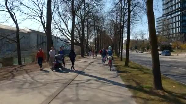 2022年3月22日 ミュンヘン ドイツ サイクリストは ムンヘンの晴れた暖かい天気で春のイザール川沿いのサイクルパスに乗ります ヨーロッパの町の川沿いの都市ツアーのサイクリスト アクティブレジャー — ストック動画