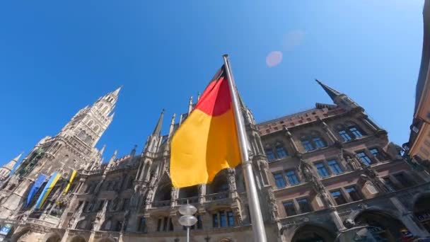 ミュンヘン ドイツ ディー ドイツ国旗ヴォル ムーエンチェンのマリエン広場 ミュンヘンのニューシティホール 晴れた天気のドイツ国旗 — ストック動画