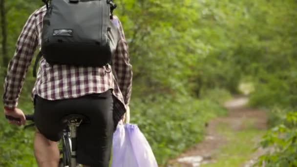 Gönüllü Bisikletçi Çöp Torbalarını Kaldırır Bisiklet Sürerken Ormanı Temizler Çevreyi — Stok video