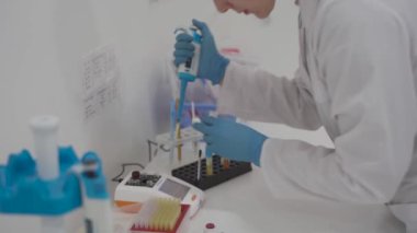 Kan analizi sırasında pipetli bir tıbbi laboratuvar asistanı. Hastane laboratuarlarındaki ekipmanlar. Hematolojik inceleme için damlatıcıyla araştırma görevlisi. Modern laboratuvarda bilim adamı.. 
