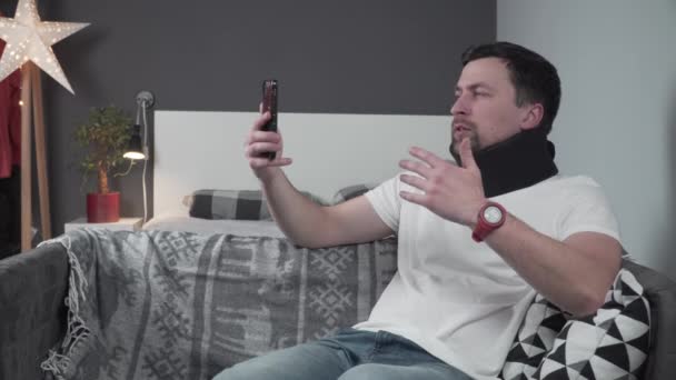 Joven Sentado Casa Sofá Hablando Videollamadas Sobre Cómo Lesionó Cuello — Vídeo de stock