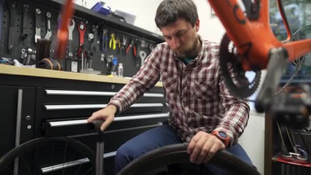 Mężczyzna Rower Mechanik Pompy Opony Rowerowe Pompą Podłogową Warsztacie Naprawy — Wideo stockowe