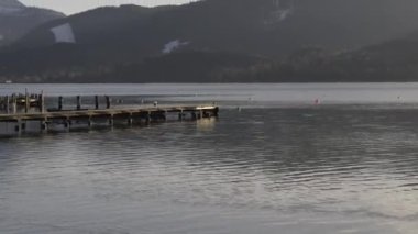 28 Nisan 2024. Tegernsee Gölü, Bavyera, Almanya. İnsanlar güneşli bahar günlerinde göl kıyısında ve Bavyera Alpleri 'ne bakan iskelede dinleniyorlar. İnsanlar ilk güneşli günleri göl kenarında yakalar.. 