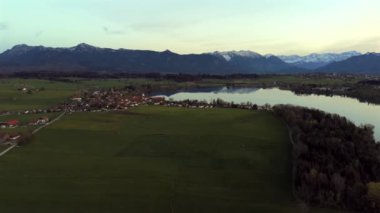 Oberbayern bei Sonnenuntergang 'dan Der Riegsee. Murnau, Bavyera, Almanya, Avrupa yakınlarındaki Riegsee Gölü 'nün havadan görüntüsü. Baharda gün batımında arka planda Ammergauer Alpen. Turizm Bölgesi Das Blaue Arazisi. 